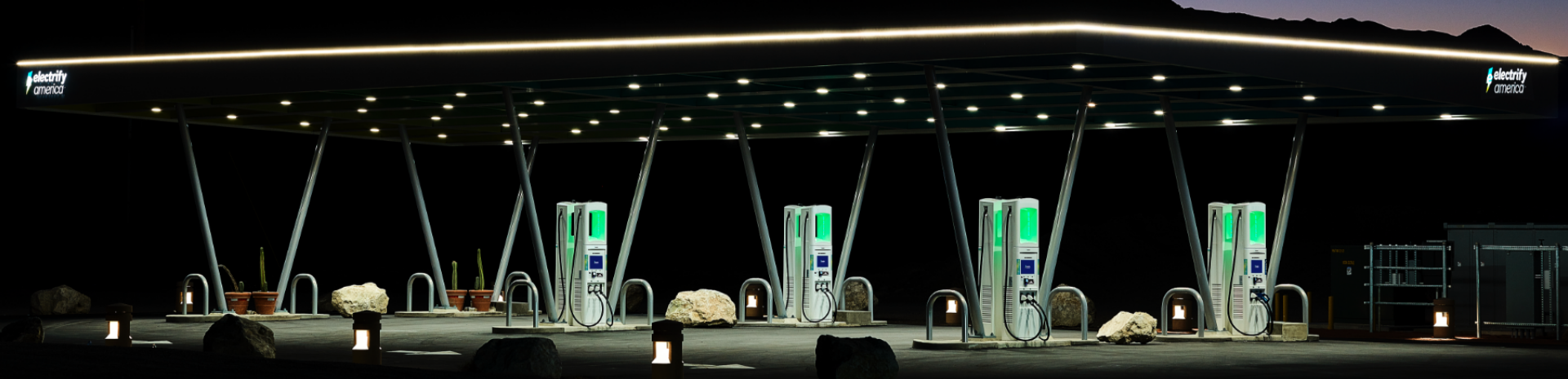 Electrify America chargers under a lighted canopy at night