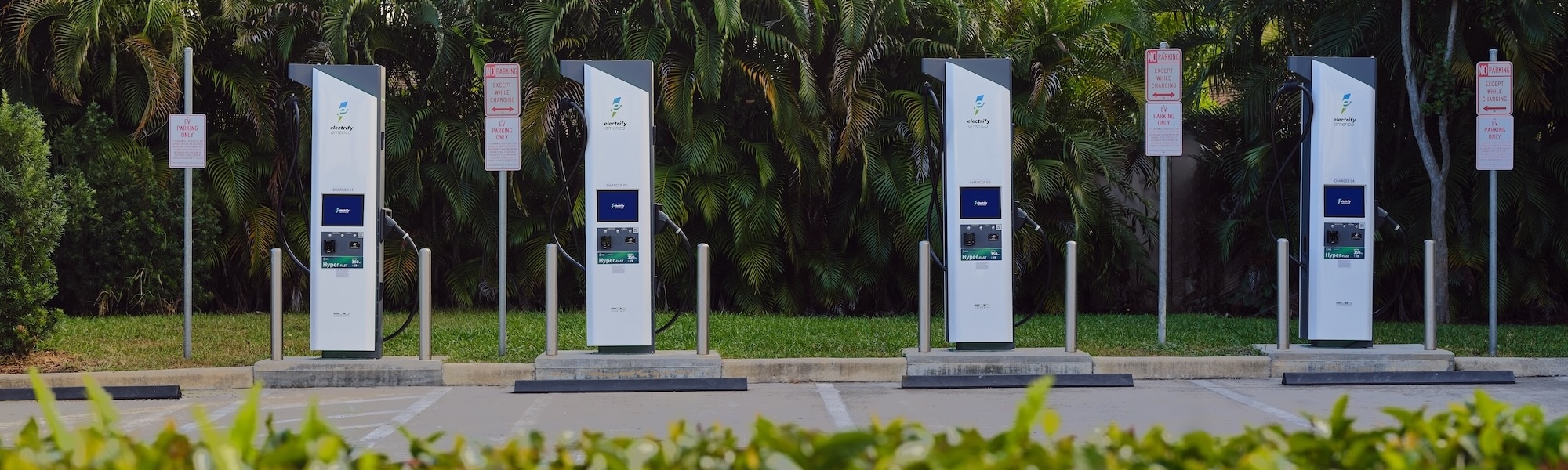 Electrify America chargers in a lush green parking lot