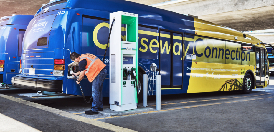 An employee charges an electric bus at SacRT's Electrify America station